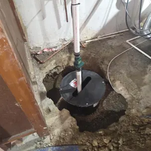 New sump basin and pump discharge line in a Centerville, Ohio basement after a backwater valve installation