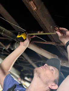 Plumber repairing copper supply pipes during a water leak repair